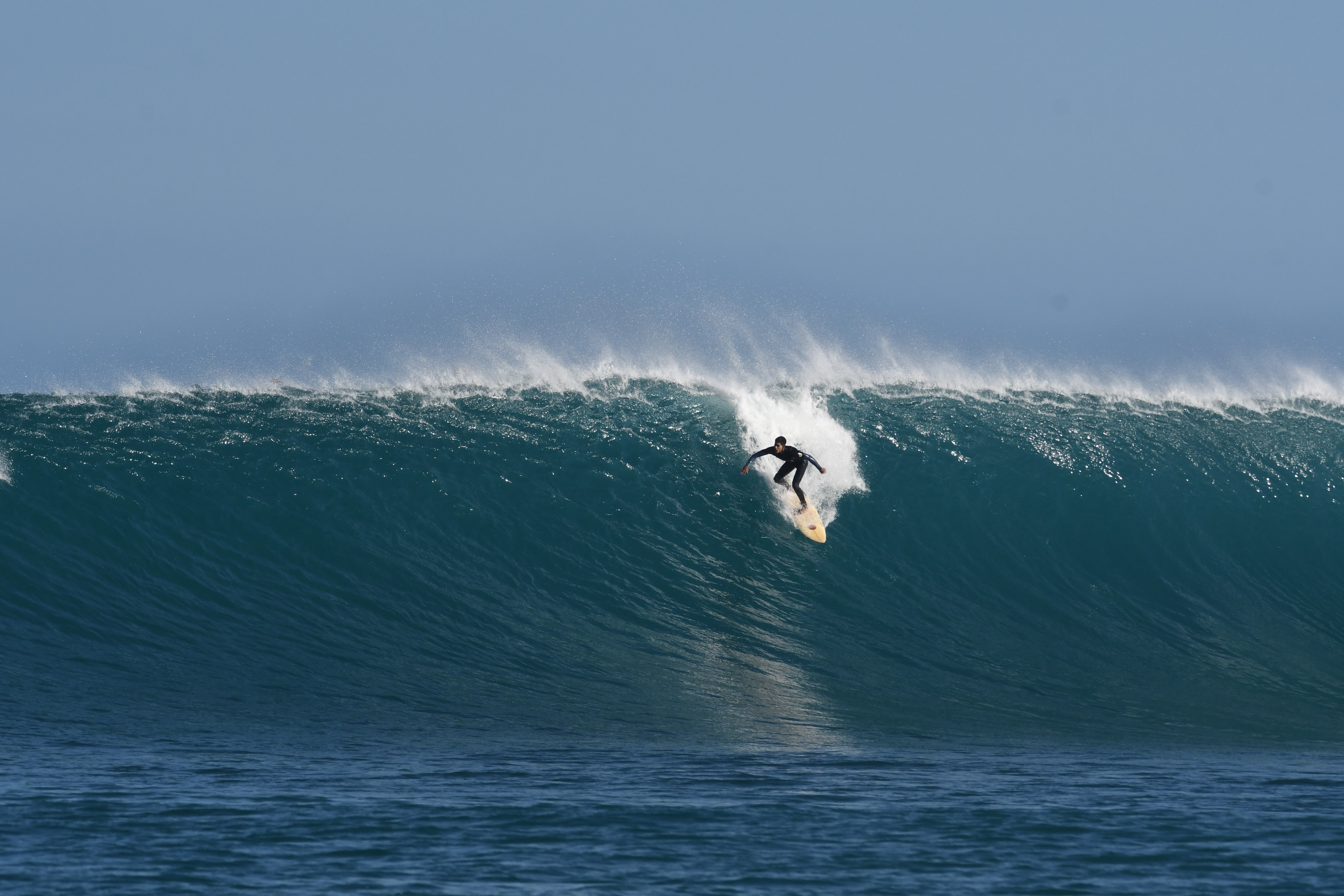 Surfer riding a powerful wave during the El Niño surf season in San Cristobal, Galapagos.